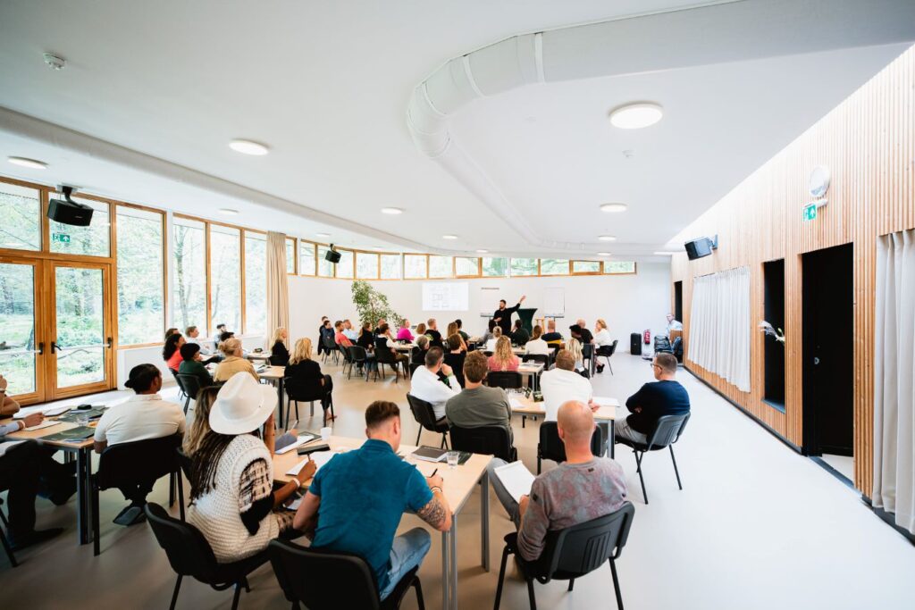 Daniel Priestly geeft een cursus in een zaal met veel personen